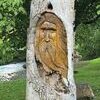 This face is one of several carved into trees along the walking trail.  LISA MAINE PHOTO